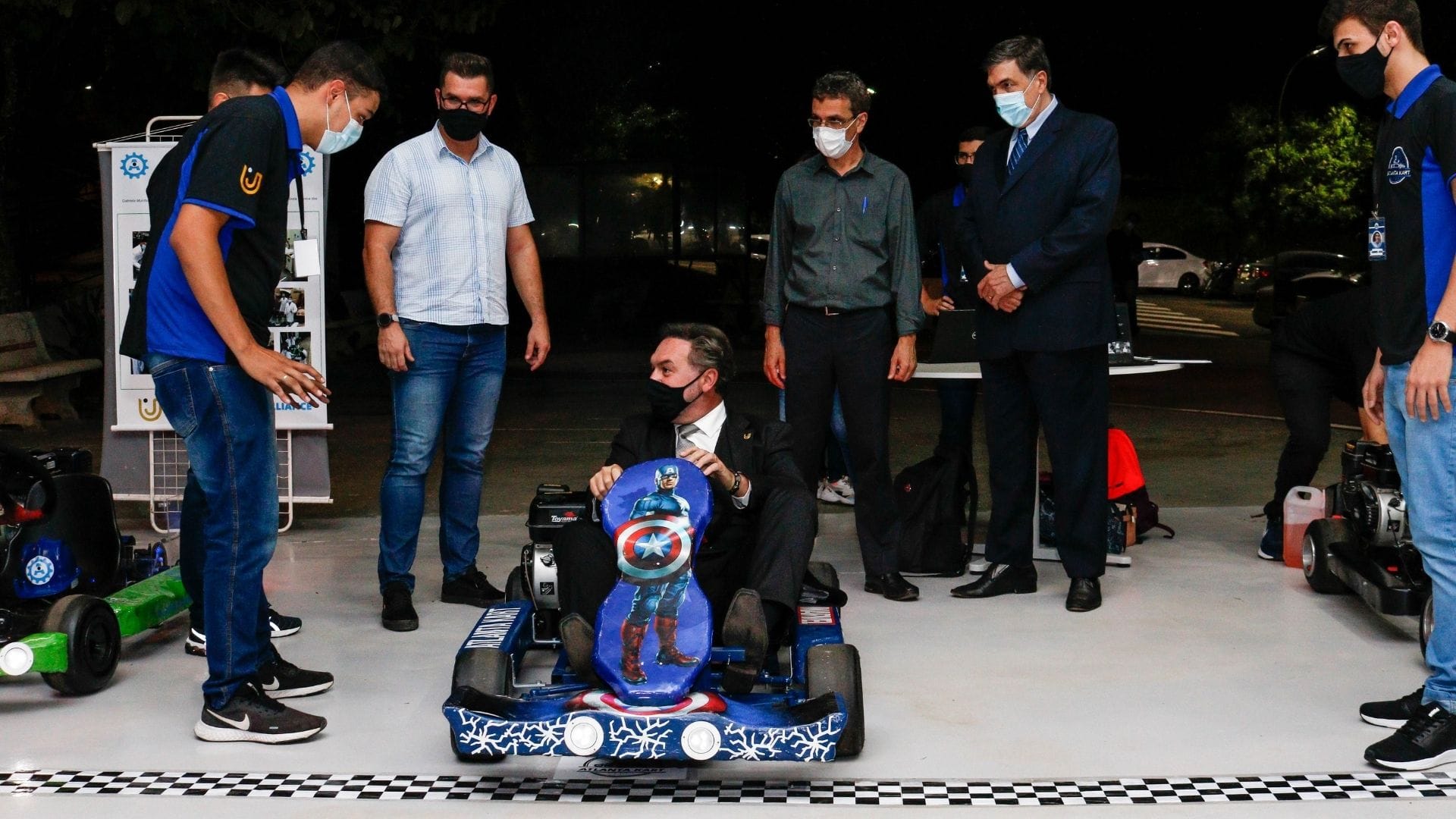 A imagem mostra o diretor da UniFAJ, Flávio Pacetta, em um carrinho de kart apresentado pelos alunos no Production Day.