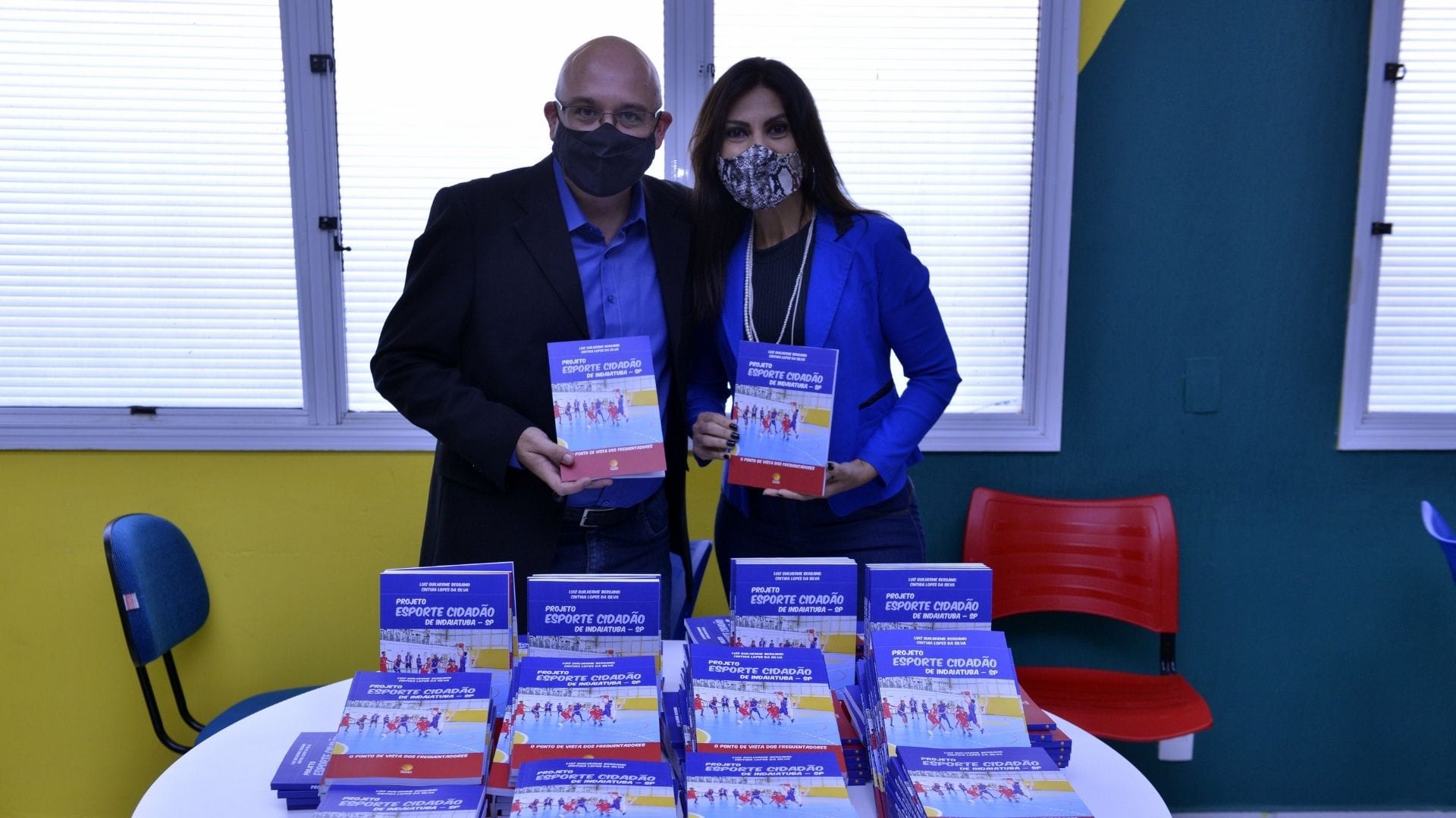 A imagem mostra o professor de Educação Física Guilherme Bérgamo posando junto ao livro lançado.
