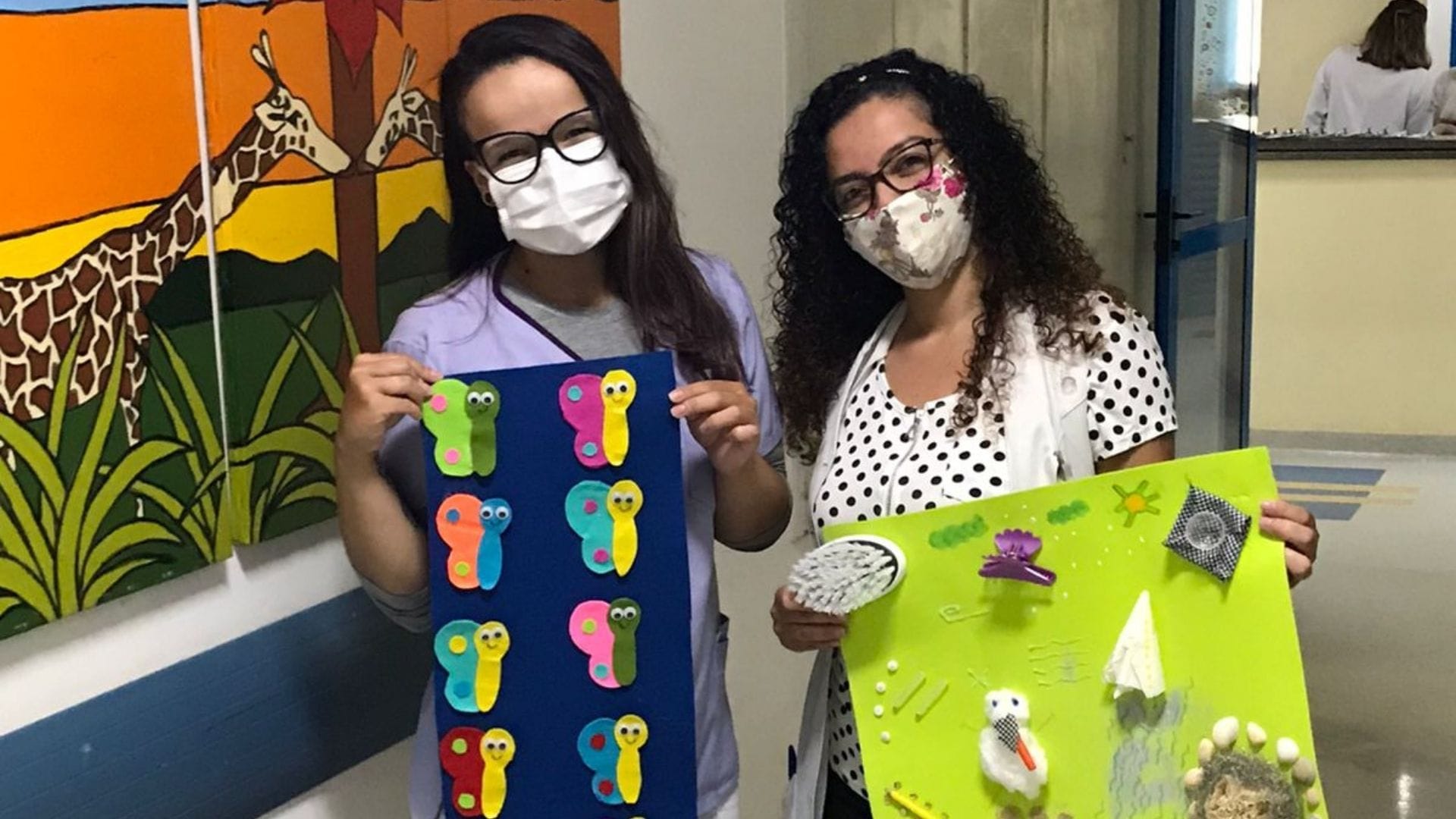 A imagem mostra uma aluna do Grupo UniEduK entregando os brinquedos terapêuticos à psicóloga do Boldrini.